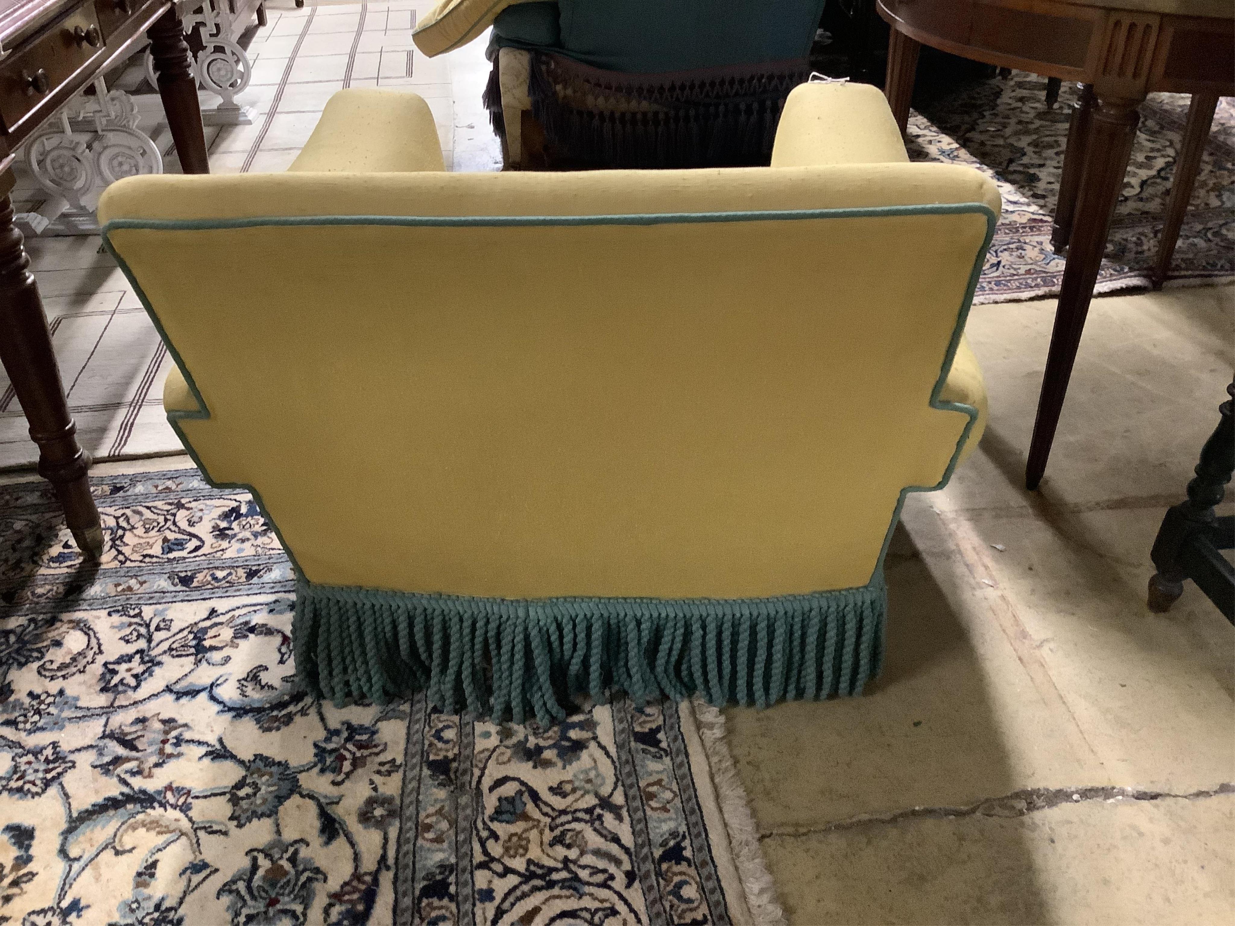 A yellow upholstered Howard style club armchair, width 82cm, depth 90cm, height 70cm. Condition - poor to fair